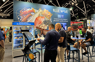 Visitors enjoying menu inspiration and seafood discussions with Blue Wave team