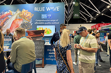Visitors enjoying menu inspiration and seafood discussions with Blue Wave team